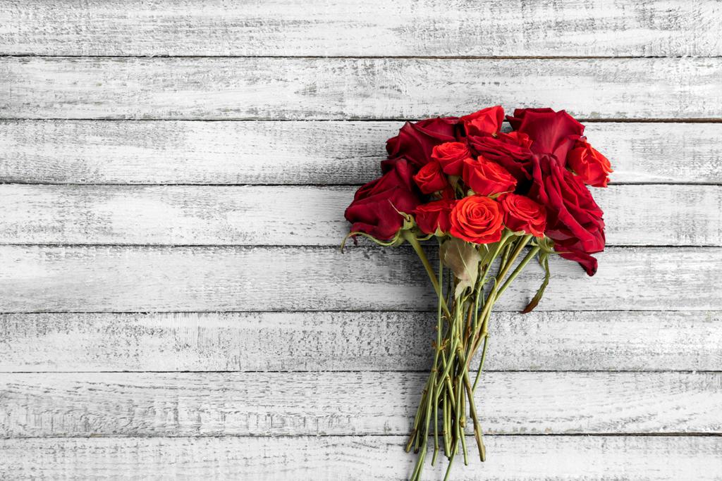 Vue du dessus du beau bouquet de roses rouges sur table en bois gris grunge avec espace de copie
 - Photo, image