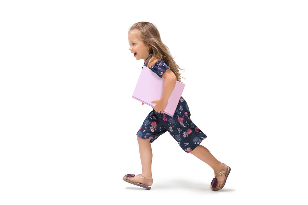 Χαμογελώντας χαριτωμένο μικρό παιδί κορίτσι τριών ετών που τρέχει πάνω από το λευκό φόντο - Φωτογραφία, εικόνα
