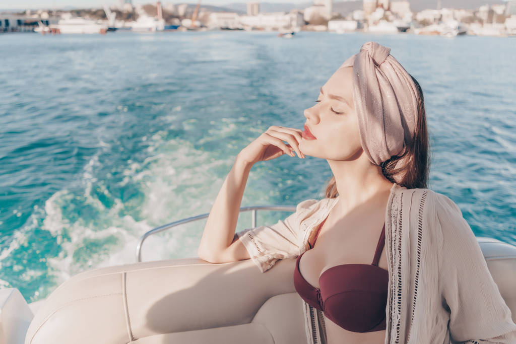 atractiva chica encantadora descansando y relajándose en un barco en el sol
 - Foto, imagen