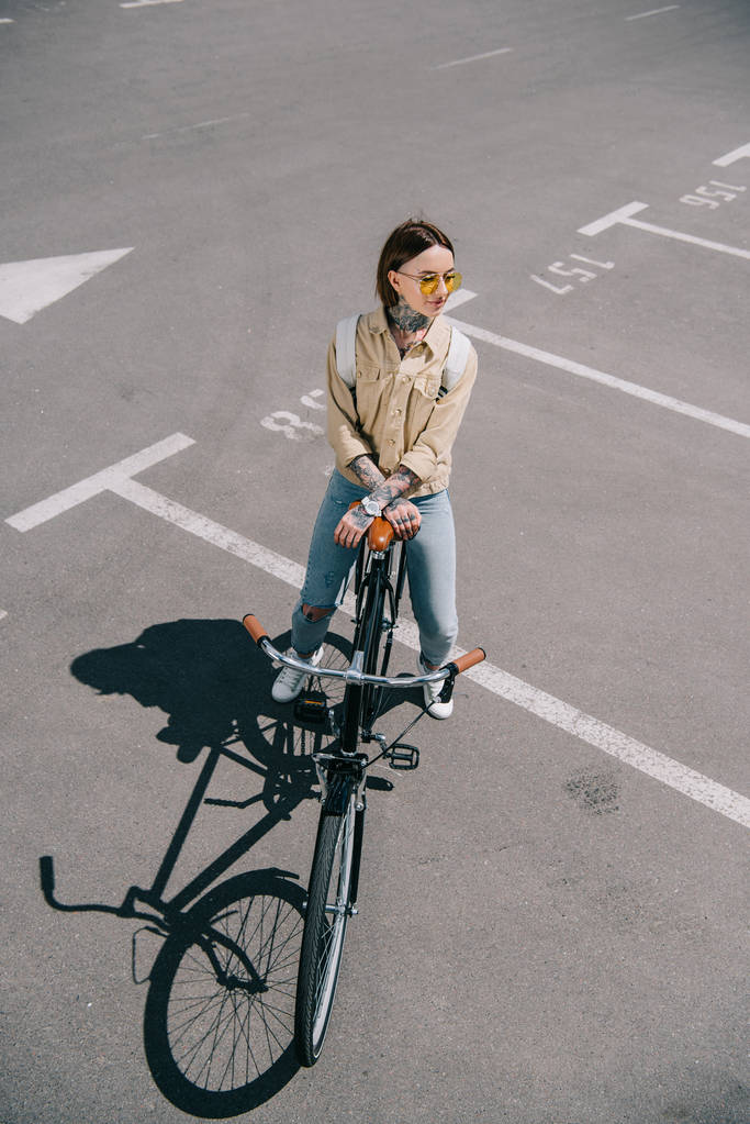 high angle view of stylish woman with bicycle at parking lot  - Photo, Image