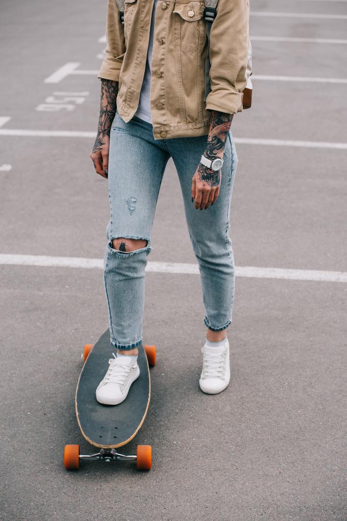 ořízne obraz Tetovaný žena skateboarding na parkovišti  - Fotografie, Obrázek