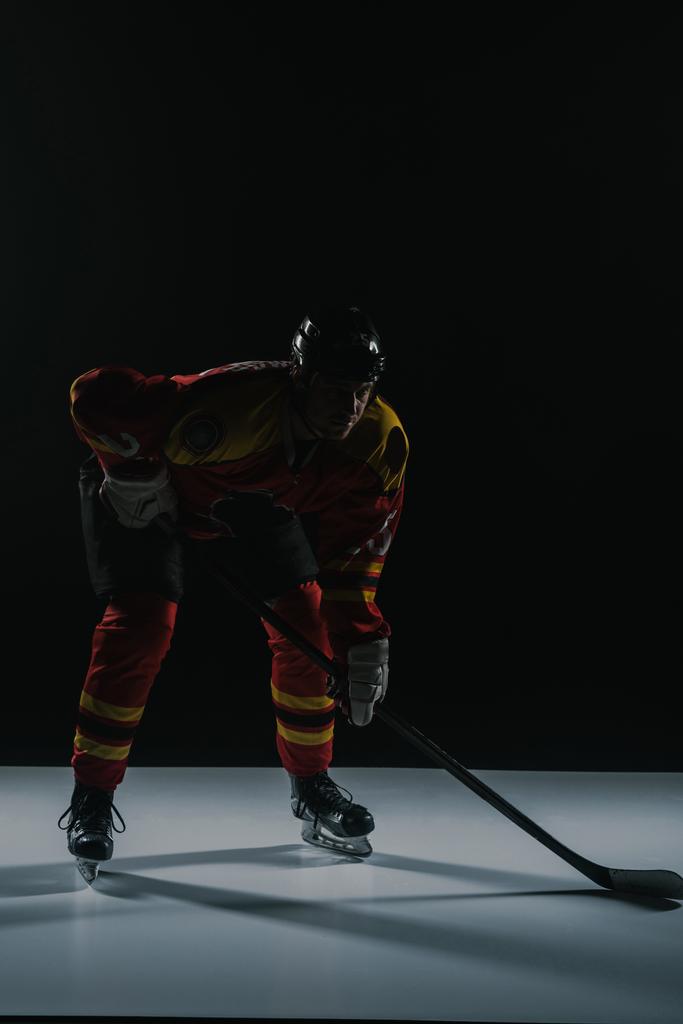 Widok pełnej długości sportowca w ochronną odzież sportowa gra hokej na lodzie na czarny - Zdjęcie, obraz