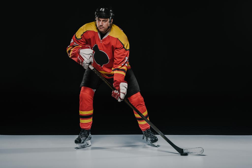 full length view of professional young ice hockey player playing hockey on black   - Photo, Image