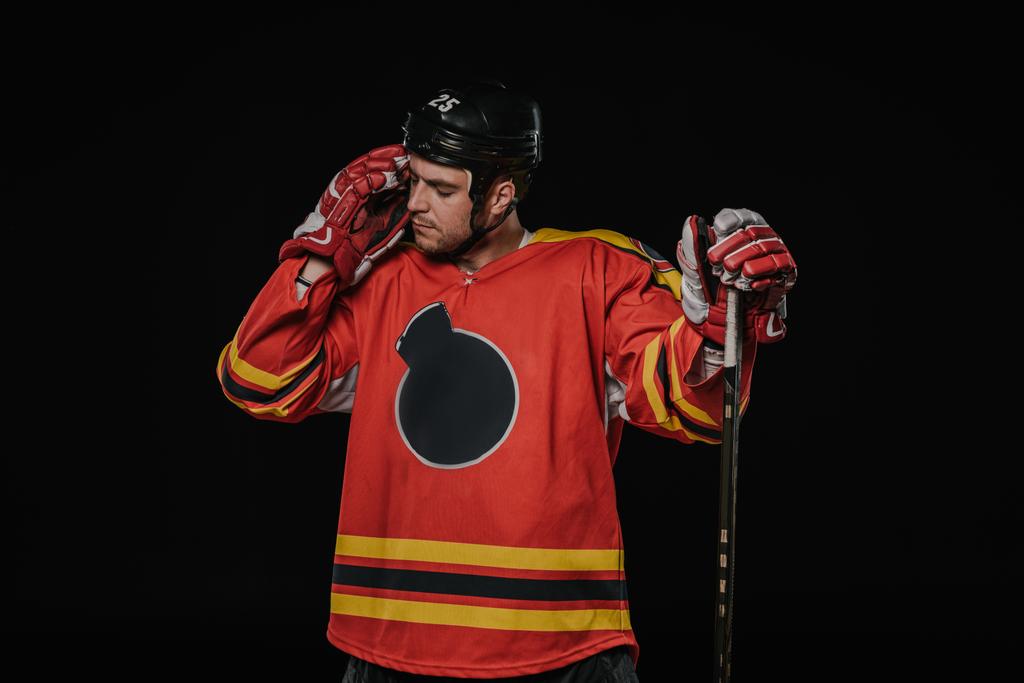 unavený hokejista stojící hokejka izolované na černém pozadí - Fotografie, Obrázek
