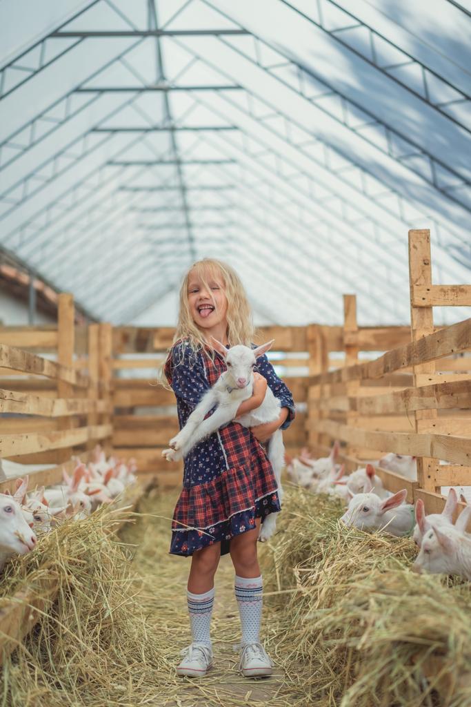 чарівна дитина викладає язик і тримає козла на фермі
 - Фото, зображення