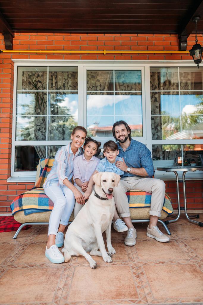 mosolygó családi labrador kutya együtt country house tornác a kanapén ül  - Fotó, kép