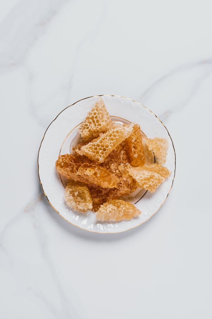 elevated view of plate with honeycombs on marble table  - Photo, Image