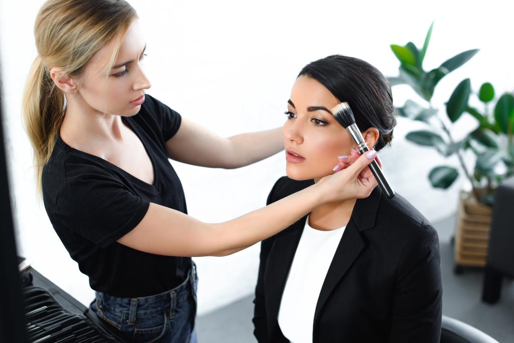 young businesswoman getting makeup done by makeup artist - Photo, Image