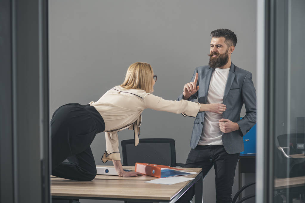 Бізнес-леді спокушає боса чоловіка за офісним столом
 - Фото, зображення