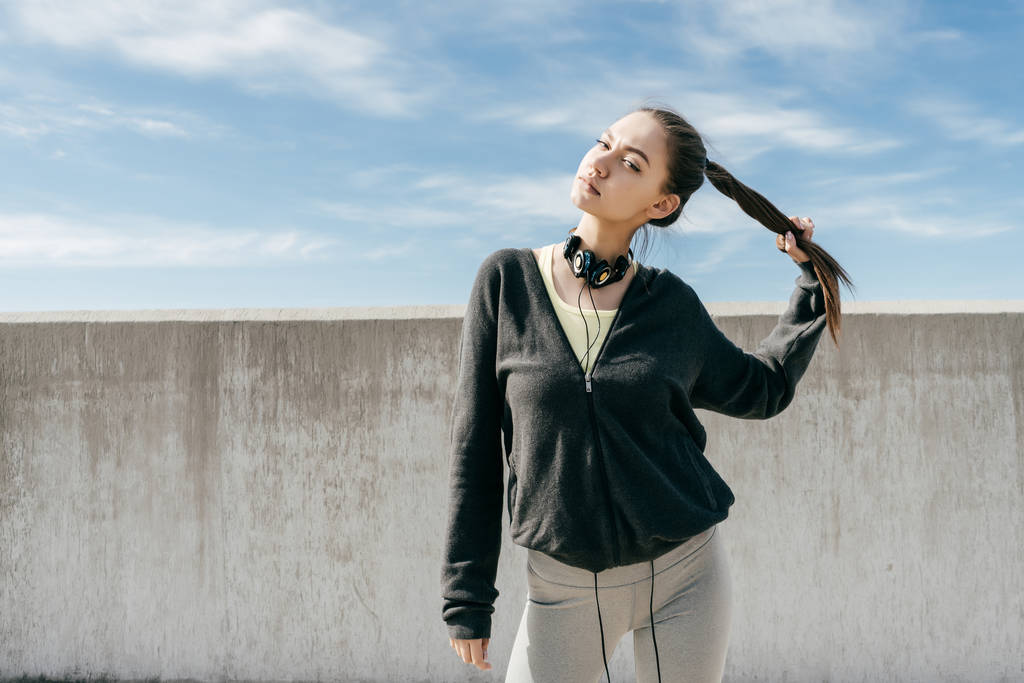 menina elegante confiante em uma jaqueta preta posando ao sol, levando um estilo de vida ativo
 - Foto, Imagem