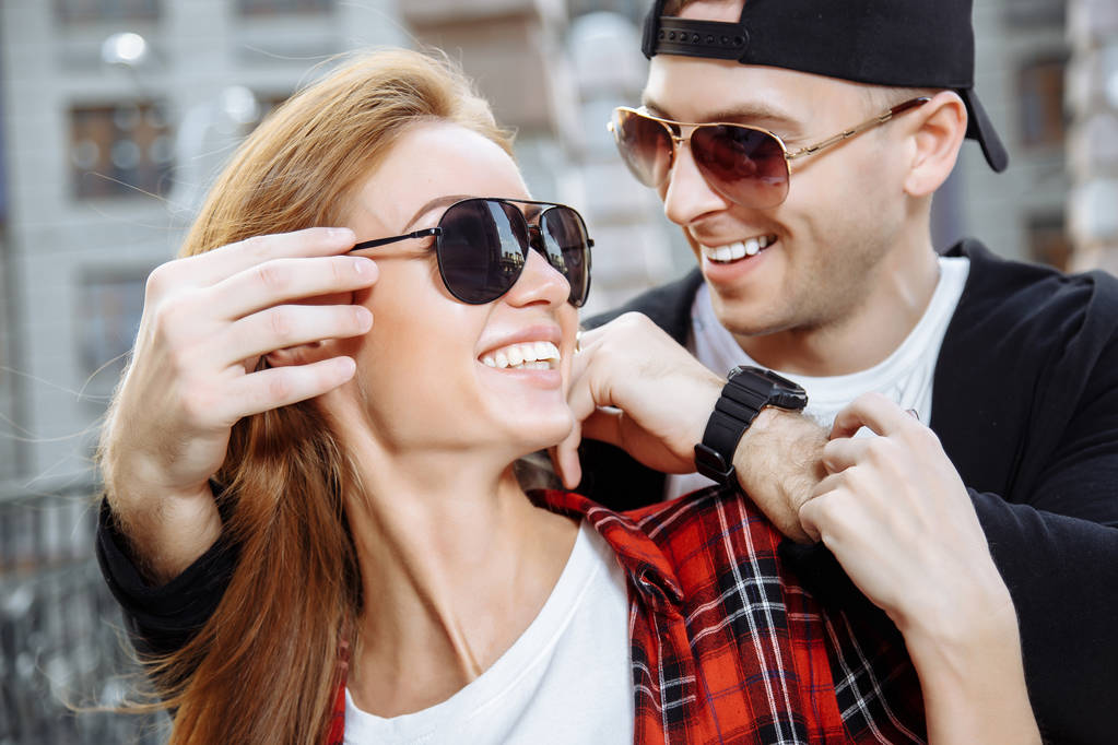 Jeune couple amoureux en lunettes de soleil s'amuser ensemble
 - Photo, image