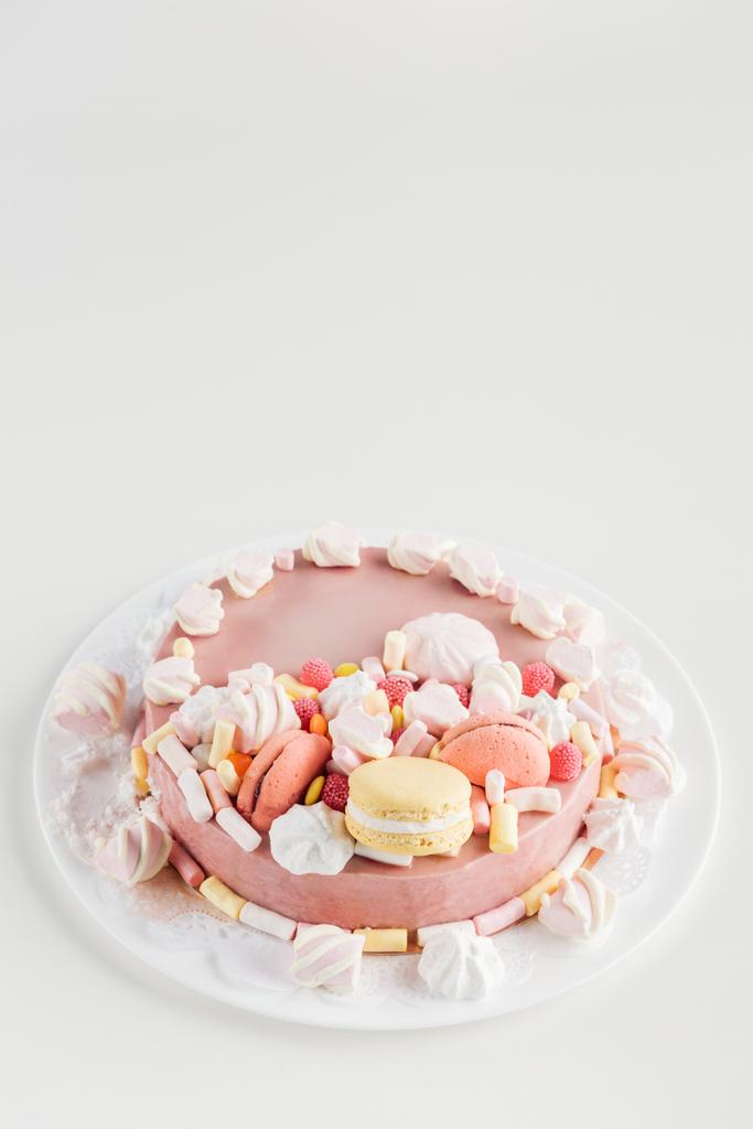 pastel rosa con malvaviscos y macarrones en plato blanco con espacio para copiar
 - Foto, imagen