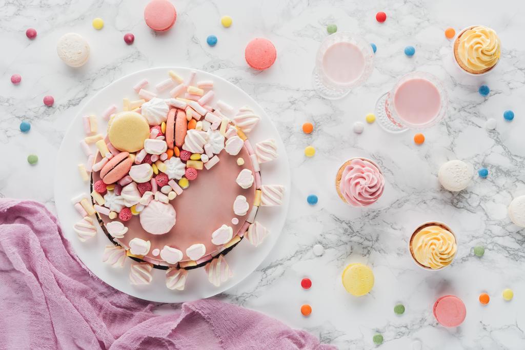 vista dall'alto della torta di compleanno rosa con marshmallow, cupcake e frappè sul tavolo di marmo
  - Foto, immagini