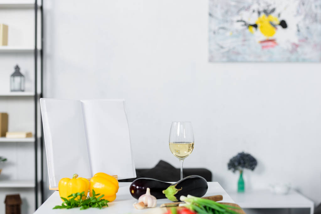 vegetables and glass of wine on kitchen counter in light modern kitchen - Photo, Image