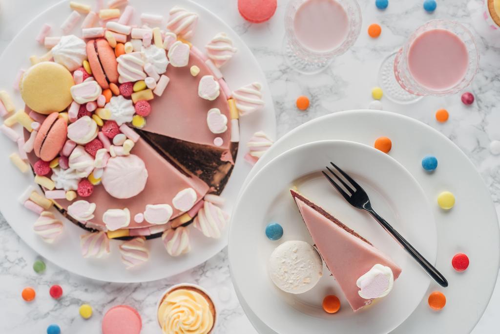 vista superior de pastel de cumpleaños, caramelos, magdalenas dulces y batido en vasos en la mesa
  - Foto, Imagen
