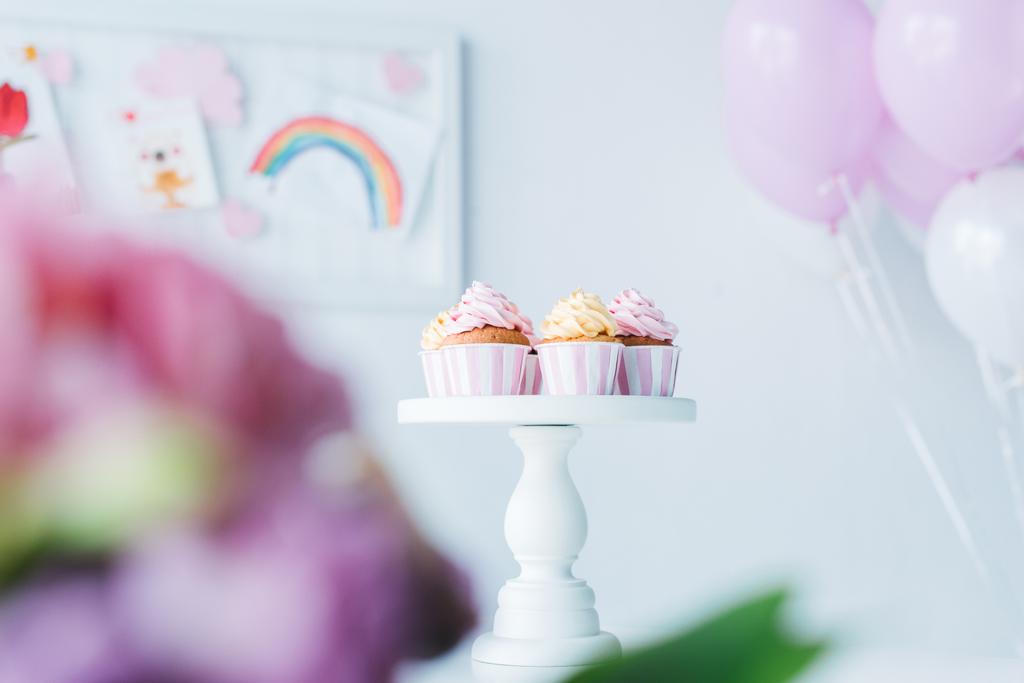 επιλεκτική εστίαση του stand με cupcakes και μάτσο αερόστατα  - Φωτογραφία, εικόνα