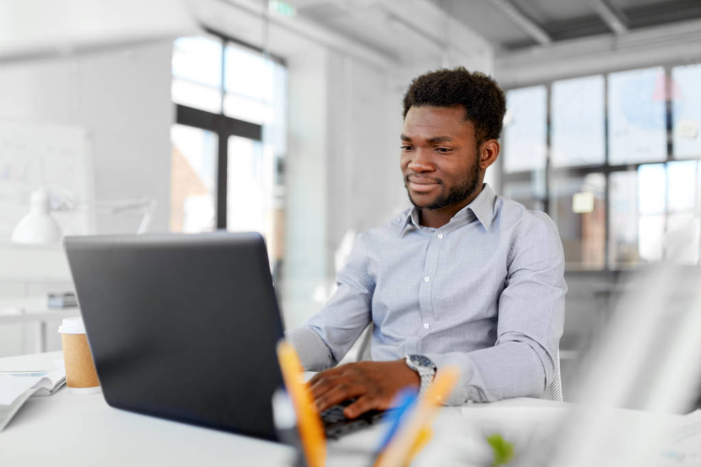 Afro-Amerikaanse zakenman met laptop op kantoor - Foto, afbeelding