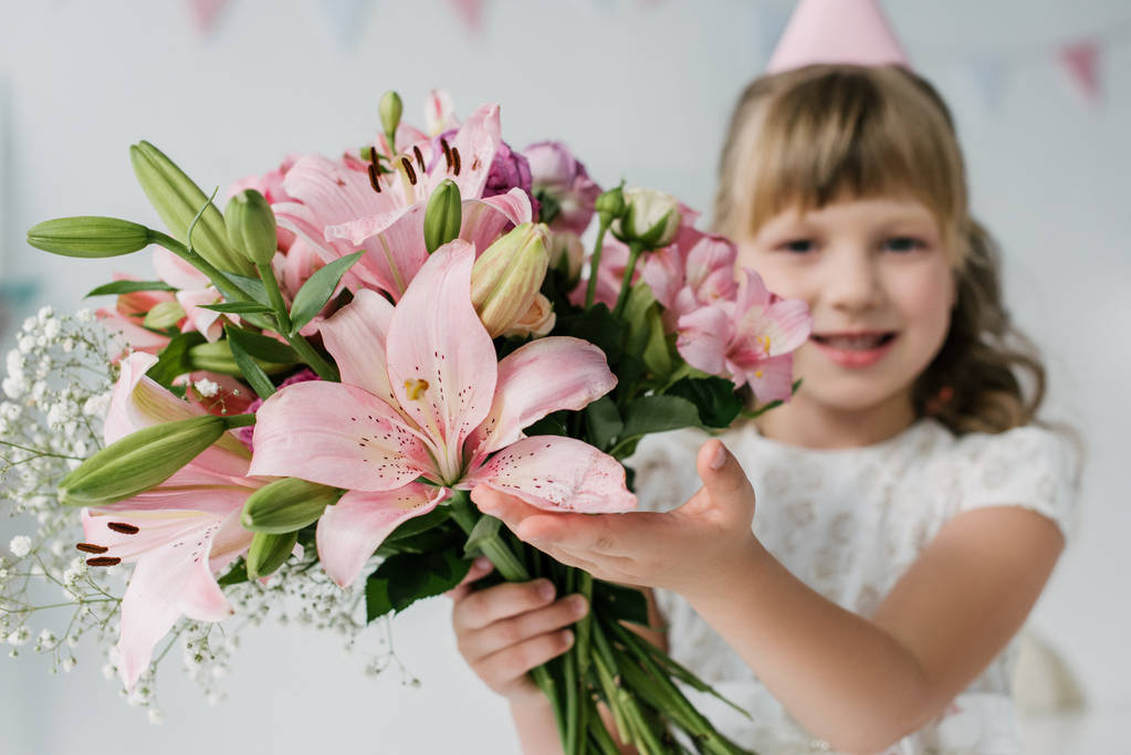 selective focus of happy birthday kid pointing on bouquet of lilies  - Photo, Image