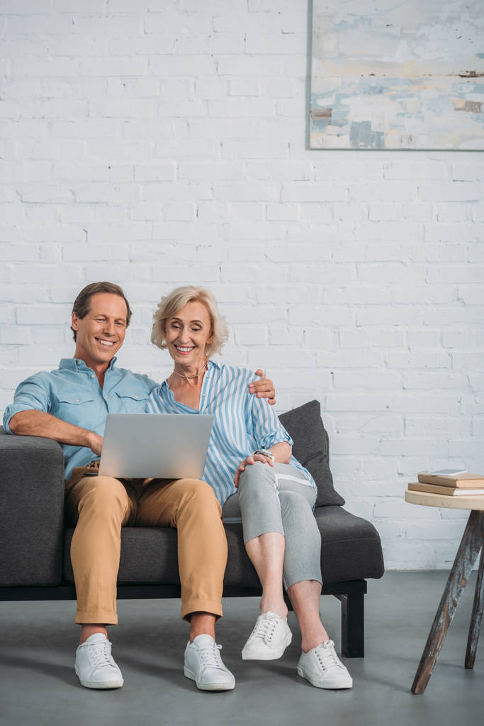 használ a laptop otthon együtt ül míg boldog idősebb pár  - Fotó, kép