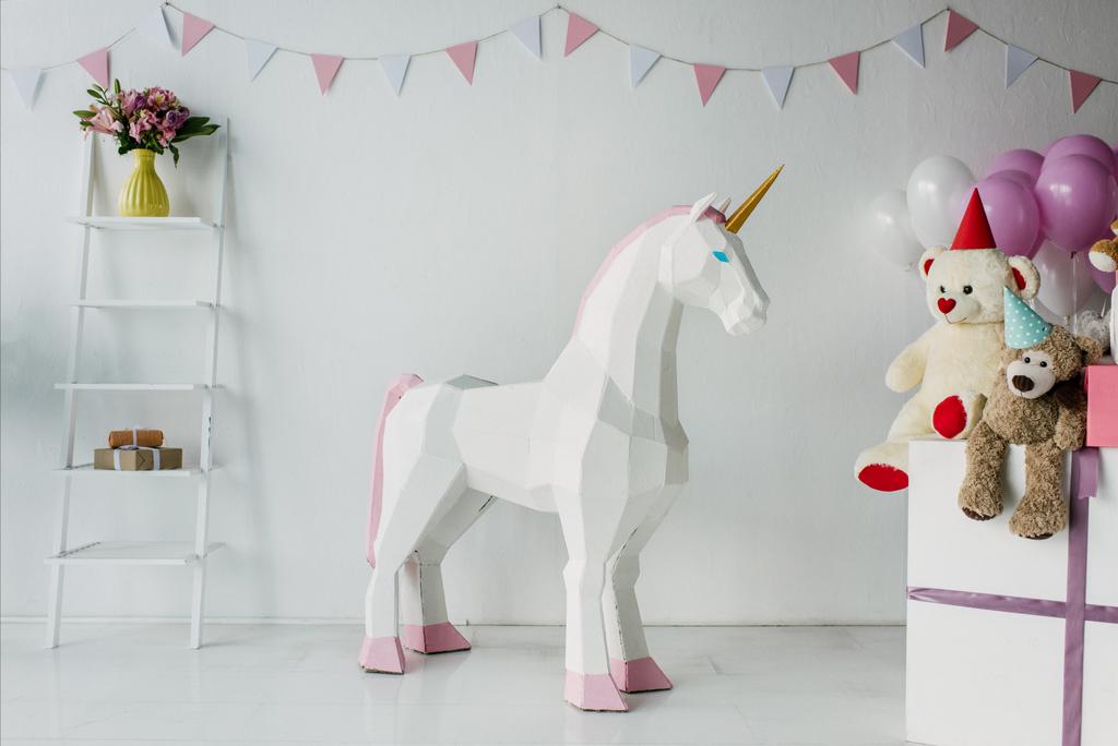 Dekoratives Einhorn, Teddybären in Zapfen und Luftballons in dekoriert für Geburtstagszimmer - Foto, Bild