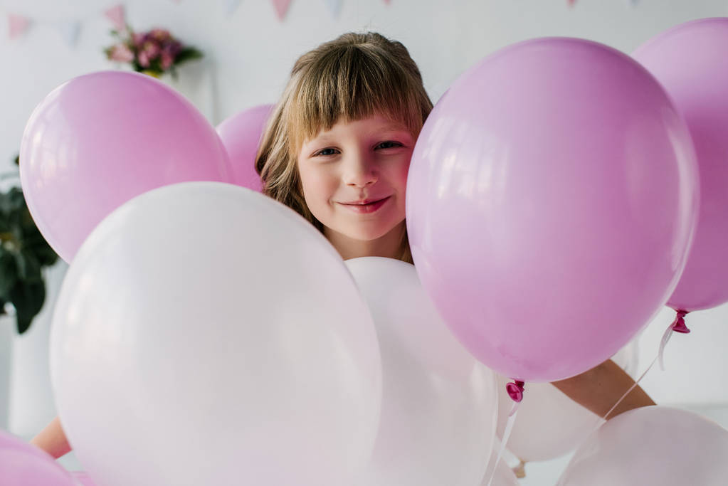 mosolygó imádnivaló gyermek állandó levegő léggömbök portréja  - Fotó, kép