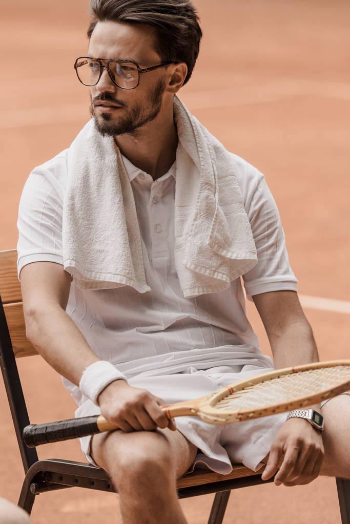 guapo tenista sentado en silla con raqueta de tenis en la cancha
 - Foto, imagen