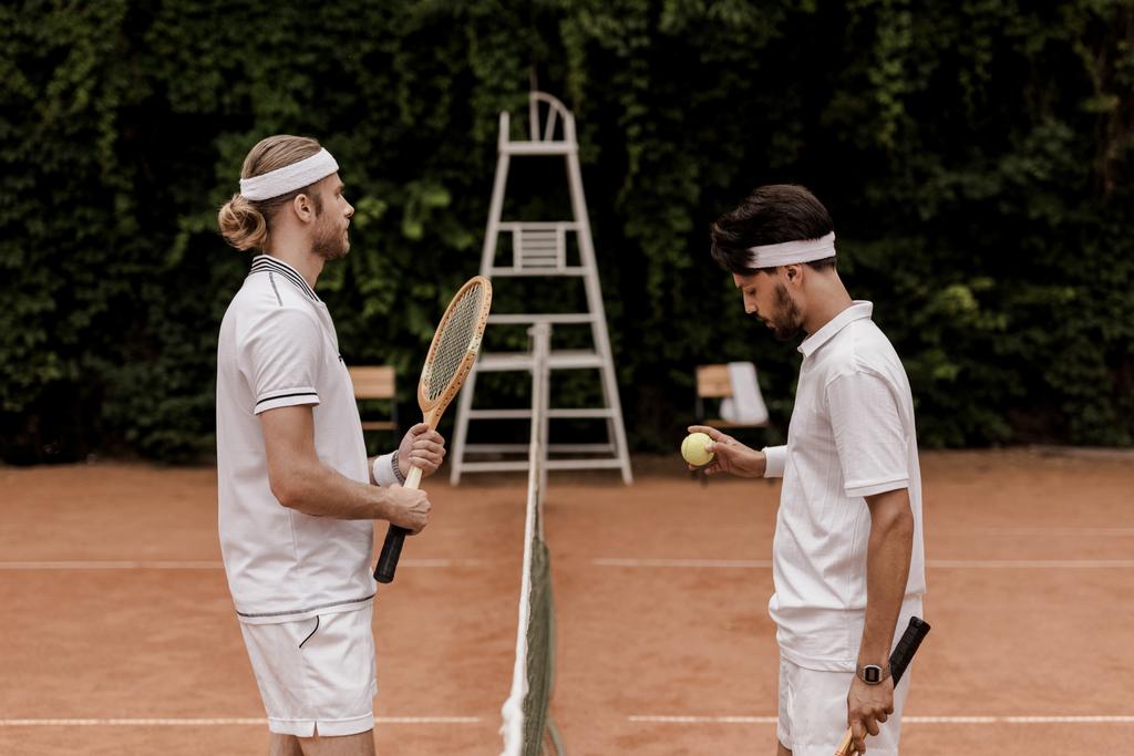 vista lateral de jugadores de tenis de estilo retro comenzando el juego en la cancha de tenis
 - Foto, Imagen