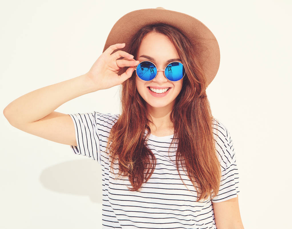 Muotokuva nuori tyylikäs nauraa tyttö malli rento kesä vaatteita ruskea hattu eristetty valkoisella pohjalla
 - Valokuva, kuva