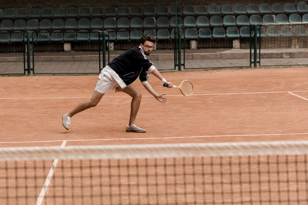 Retro yakışıklı adam raketle tenis kortunda tenis oynamaya tarz - Fotoğraf, Görsel