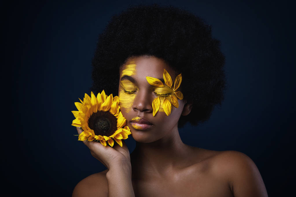 Lovely африканських жінка з соняшнику і творчих макіяж на її обличчі - Фото, зображення