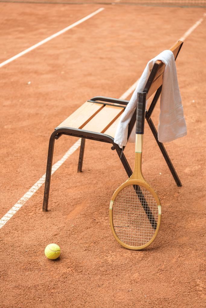 close up of chair with tennis ball, retro wooden racket and towel on tennis court - Photo, Image