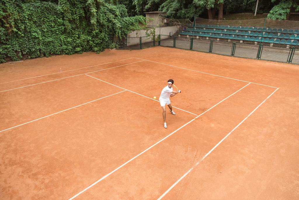 man in white sportswear playing tennis with racket and ball on court - Photo, Image