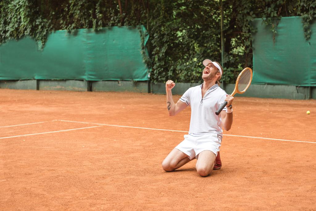 Блондинка победитель с ракеткой празднует и на коленях на теннисном корте
 - Фото, изображение