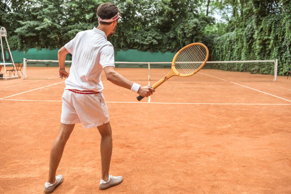 vista trasera del tenista con raqueta de madera retro en pista de tenis
 - Foto, Imagen