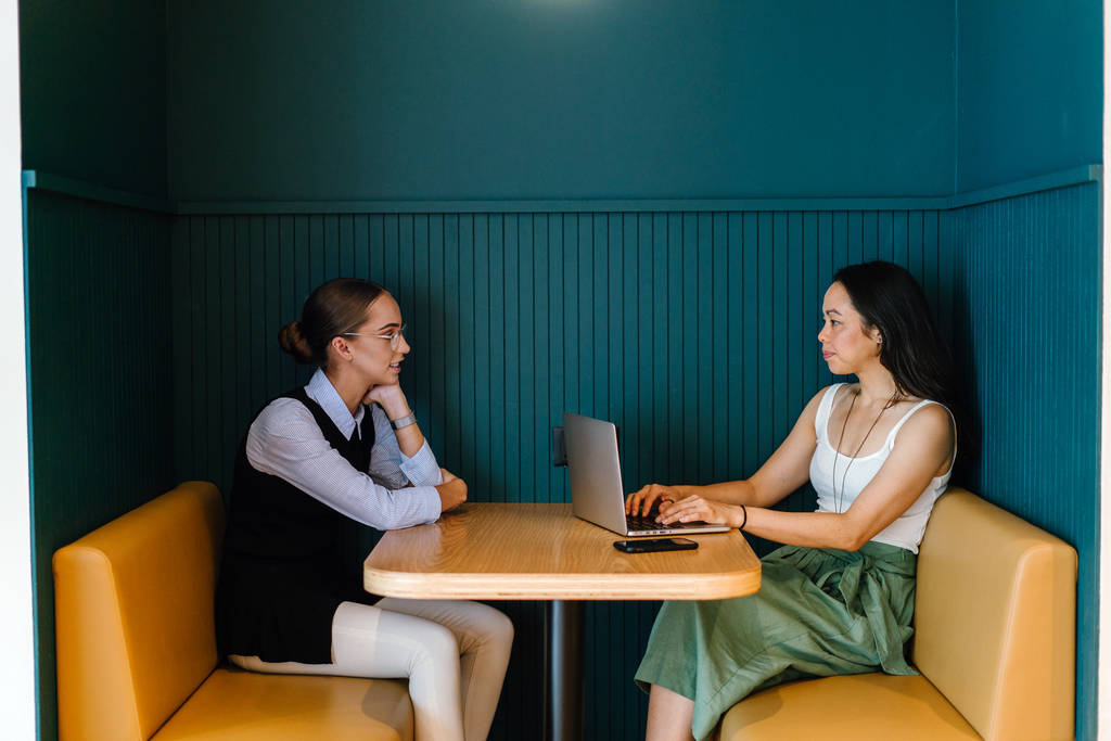 dwóch przedsiębiorców pracuje na laptopie siedząc przy stole w nowoczesnym biurze - Zdjęcie, obraz
