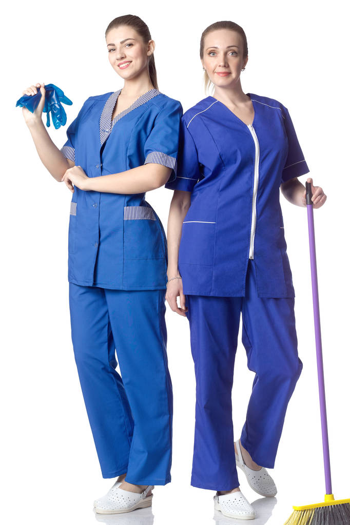 Kaksi naista puvussa siivooja, seistä täyspitkä väline puhdistukseen. Eristetty valkoisella pohjalla
. - Valokuva, kuva