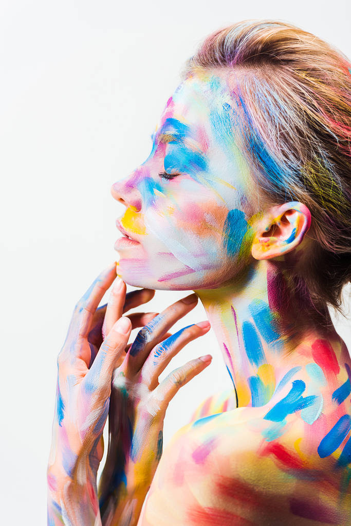 vista lateral de chica atractiva con colorido arte del cuerpo brillante tocando la barbilla aislada en blanco
  - Foto, Imagen
