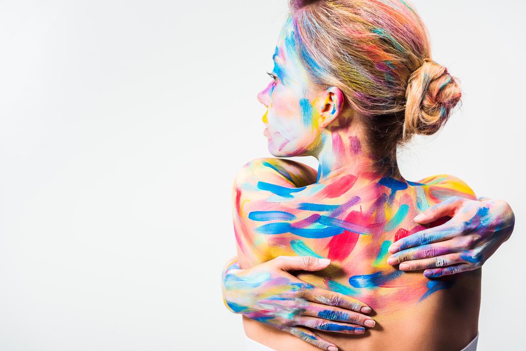 vista posterior de chica atractiva con colorido arte del cuerpo brillante tocando espalda aislada en blanco
   - Foto, imagen