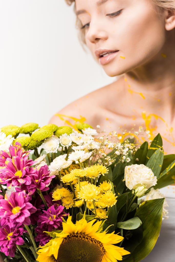 attraktive Frau mit Blumenstrauß und gelber Farbe auf Körper isoliert auf weiß - Foto, Bild