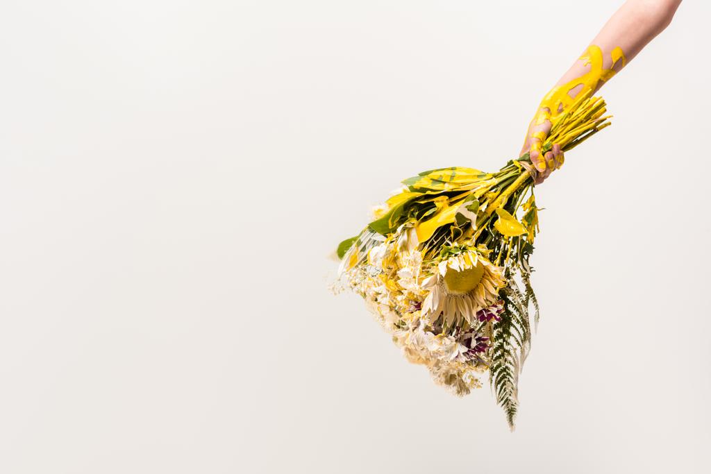 cropped image of woman with bouquet of flowers and yellow paint on body isolated on white - Photo, Image