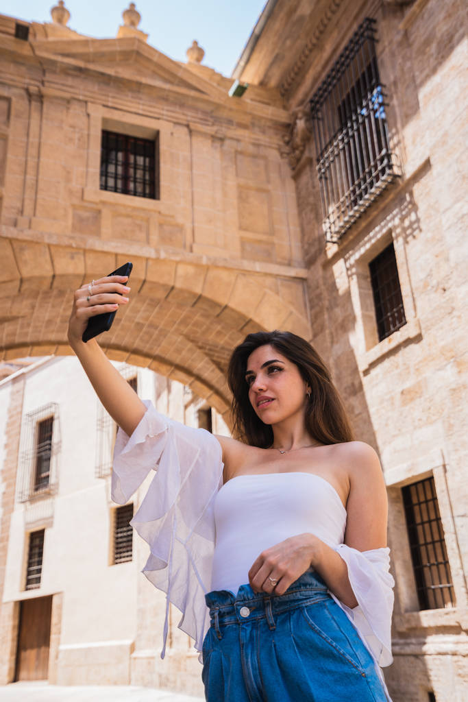 Чарівний молодих жінок у випадкових спорядження позують для selfie стоячи на дивовижні вулиці Валенсії, сонячний день - Фото, зображення