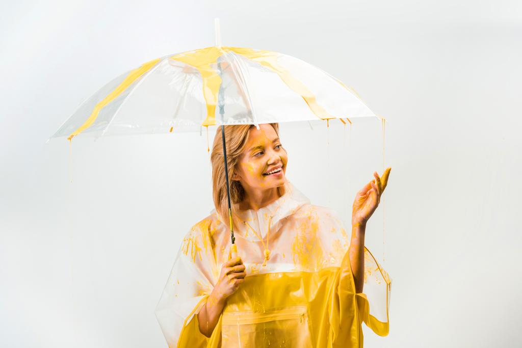 vrouw permanent onder paraplu en ontroerend druipende verven geïsoleerd op wit - Foto, afbeelding