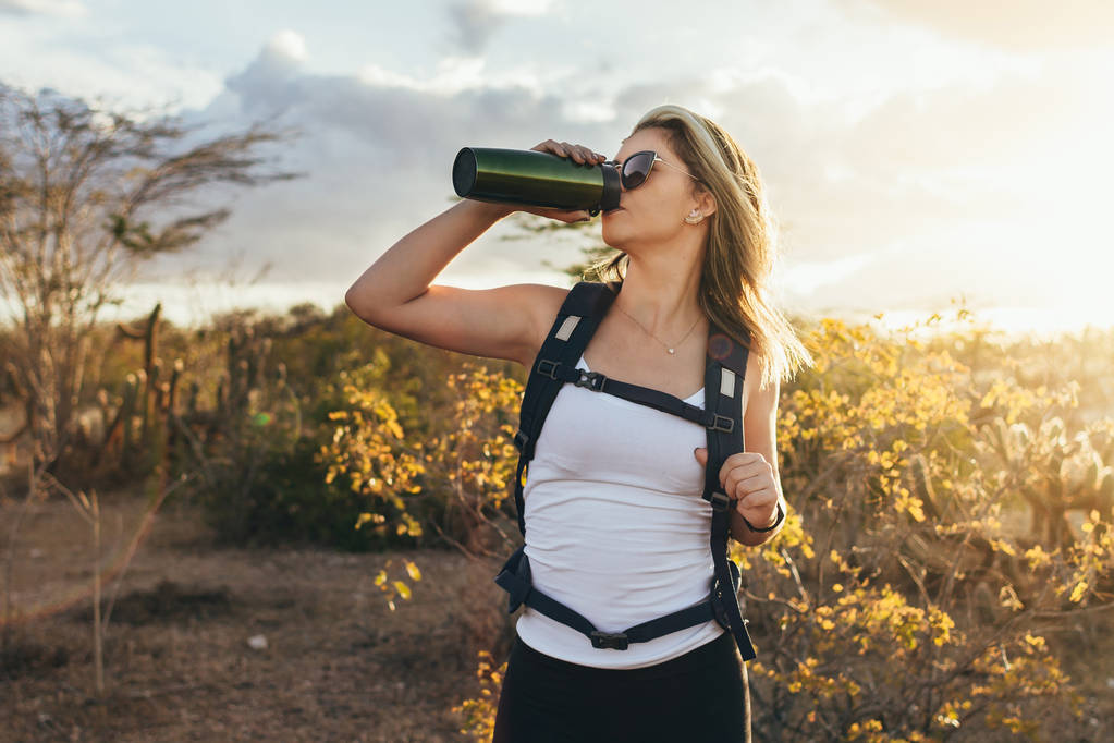 Жінка взяти перерву, щоб пити з пляшки води той час піших прогулянок в Бразильське Каатинга - Фото, зображення