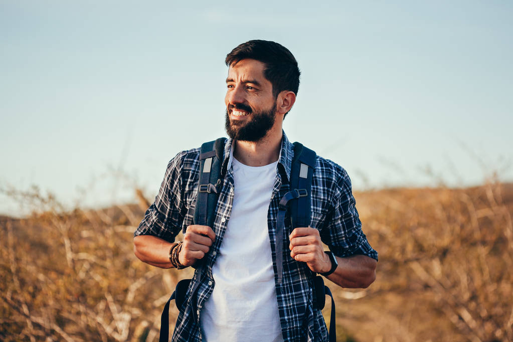Happy young man hiking with backpack - Photo, Image