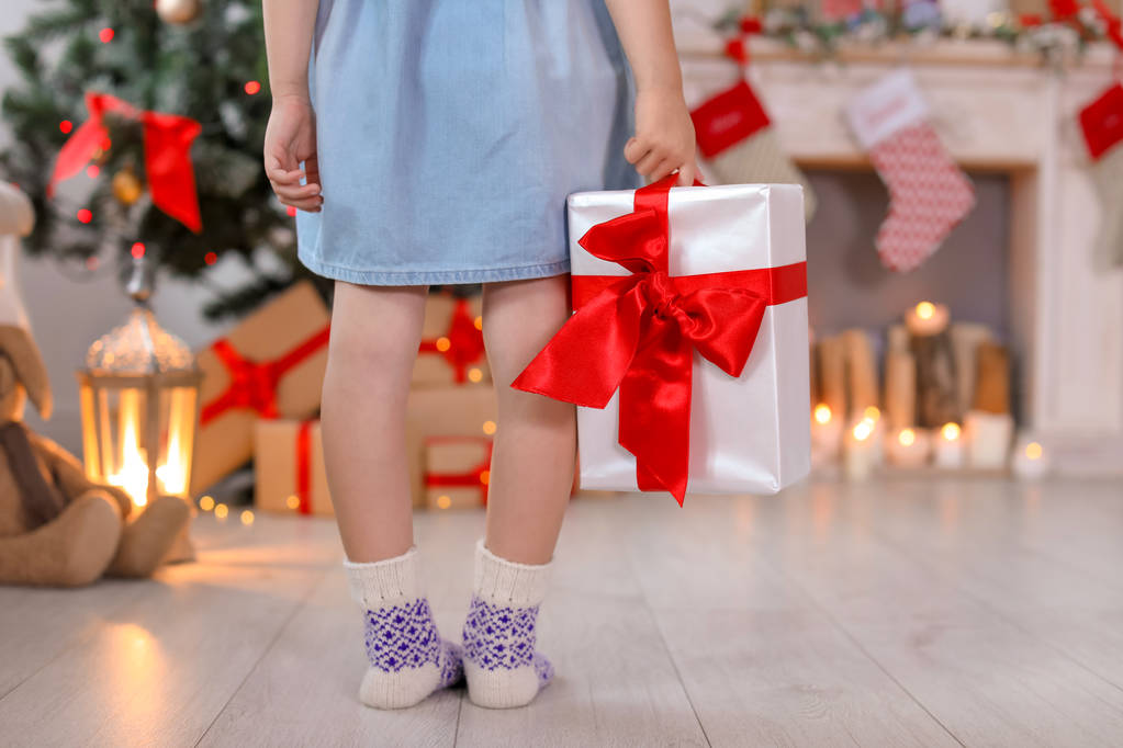 クリスマス ギフト ボックスを自宅の暖かい靴下でかわいい小さな子供 - 写真・画像