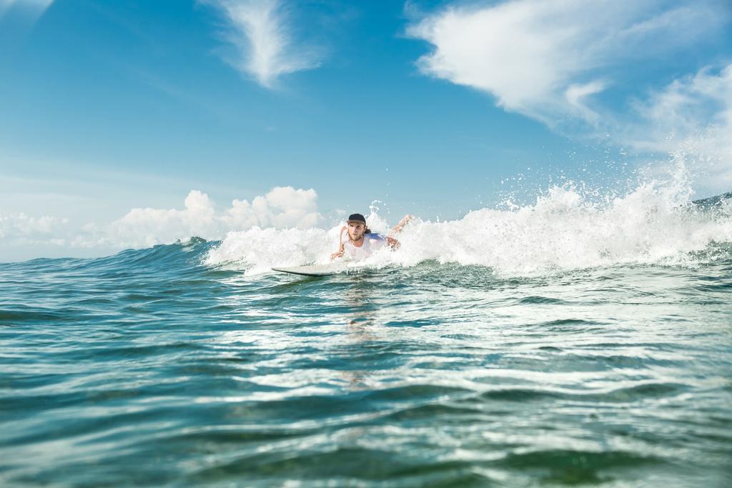 mężczyzna surfer pływanie na pokładzie surfingu w oceanu przy plaży Nusa Dua, Bali, Indonezja - Zdjęcie, obraz