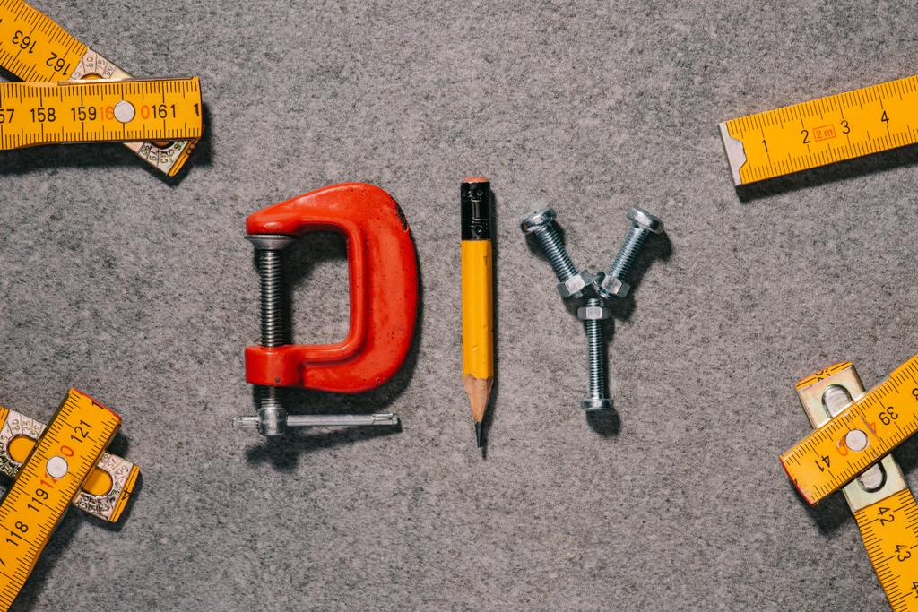 κάτοψη του word diy από εργαλεία σε γκρι επιφάνεια - Φωτογραφία, εικόνα