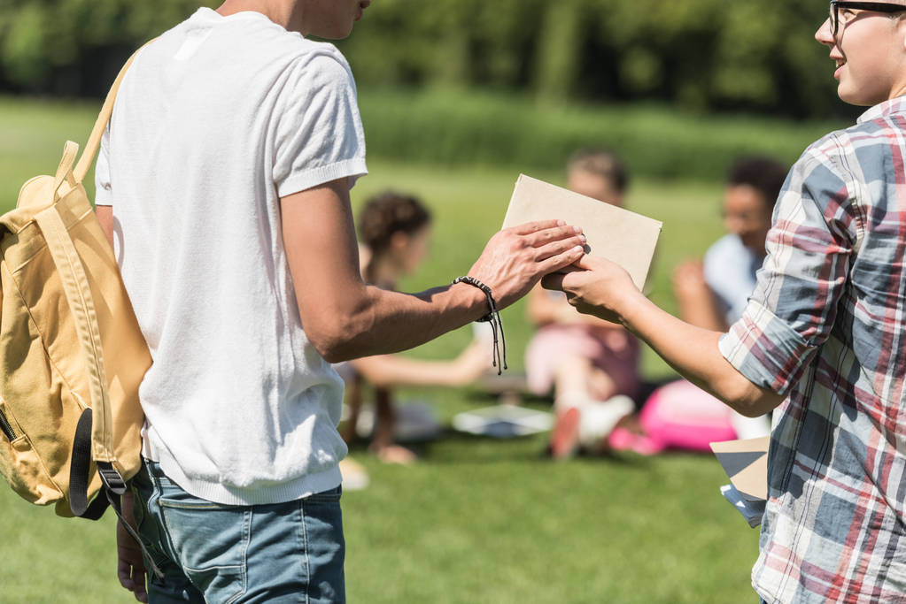 recortado tiro de adolescentes sosteniendo libro en parque
 - Foto, imagen