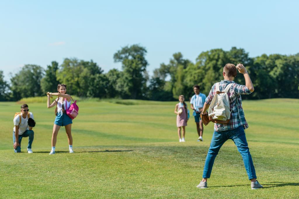 felizes amigos adolescentes jogando beisebol no prado verde no parque
 - Foto, Imagem