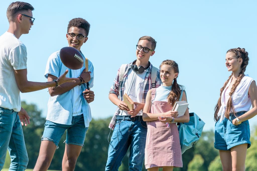 boldog többnemzetiségű tizenévesek játszik rögbi labdát park - Fotó, kép